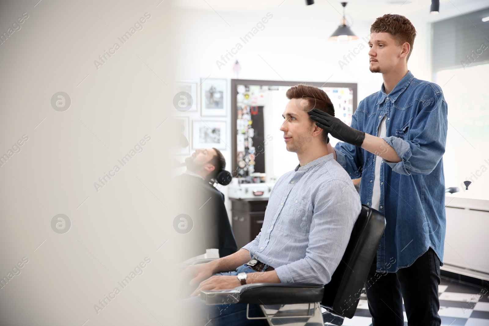 Photo of Professional barber working with client in hairdressing salon. Hipster fashion