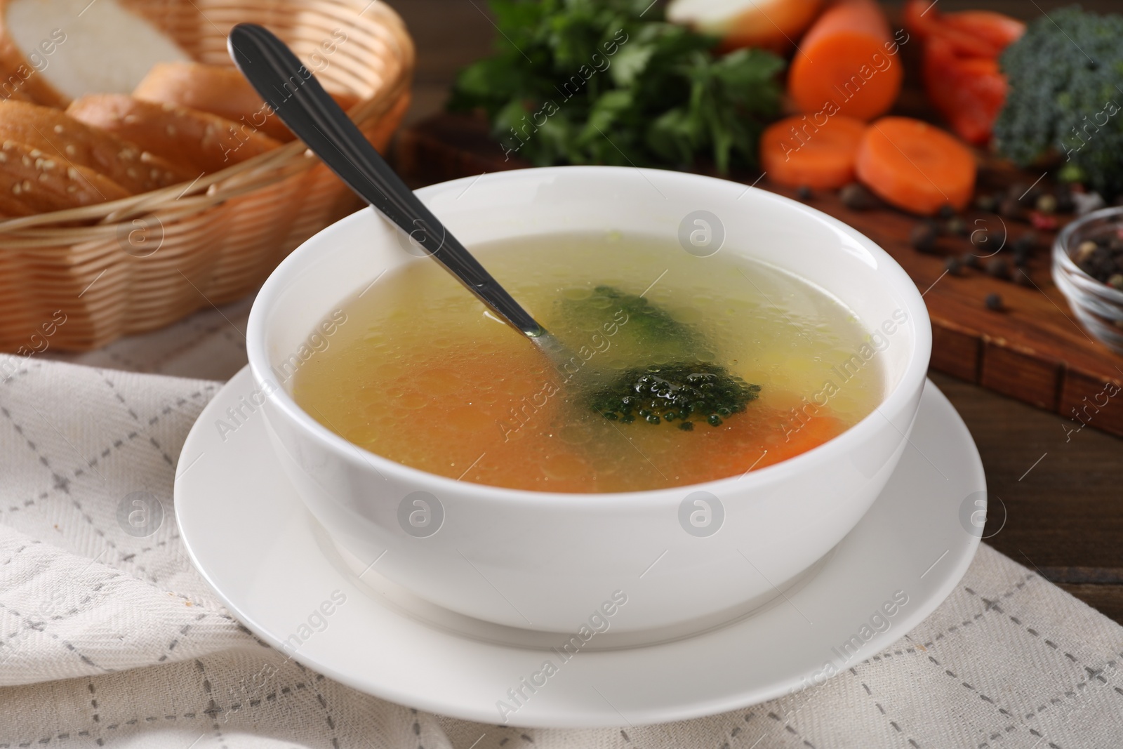 Photo of Tasty soup with vegetables in bowl served on wooden table, closeup
