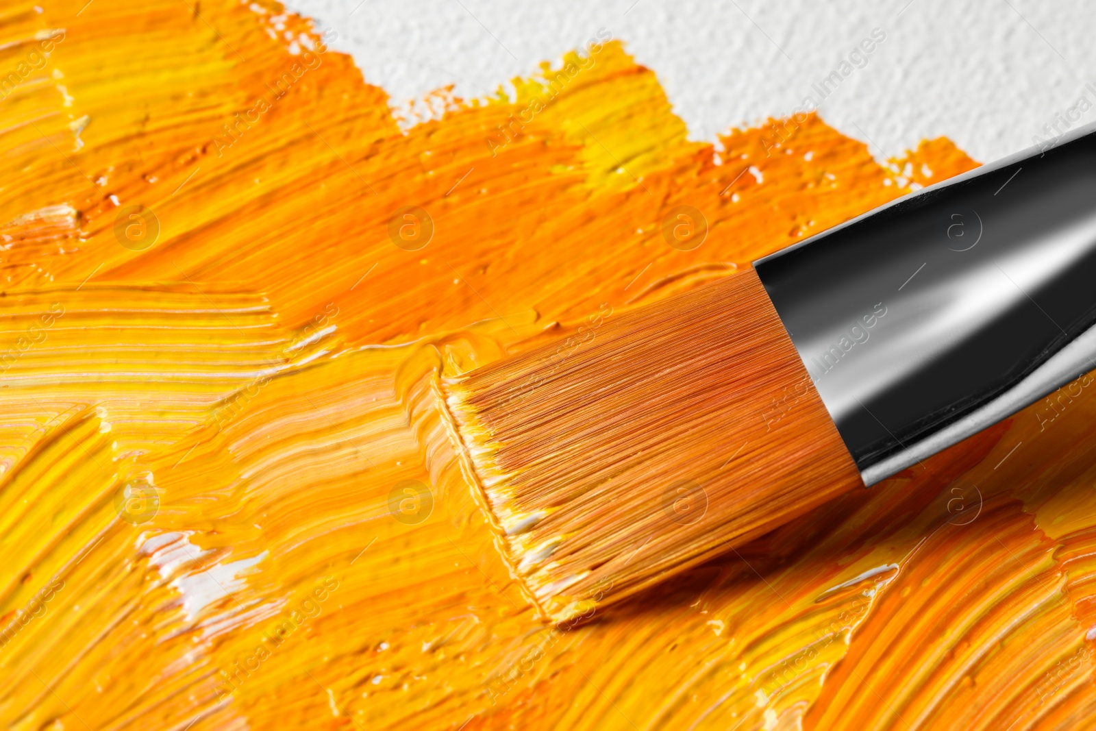 Photo of Painting beautiful strokes of colorful oil paints on canvas, closeup