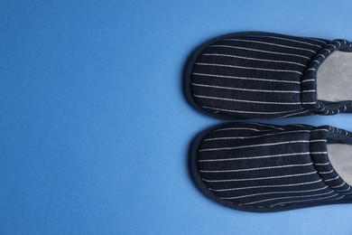 Photo of Pair of stylish slippers on blue background, top view. Space for text