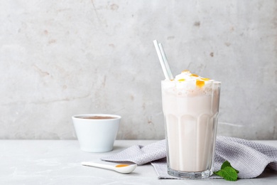 Glass with delicious milk shake on table