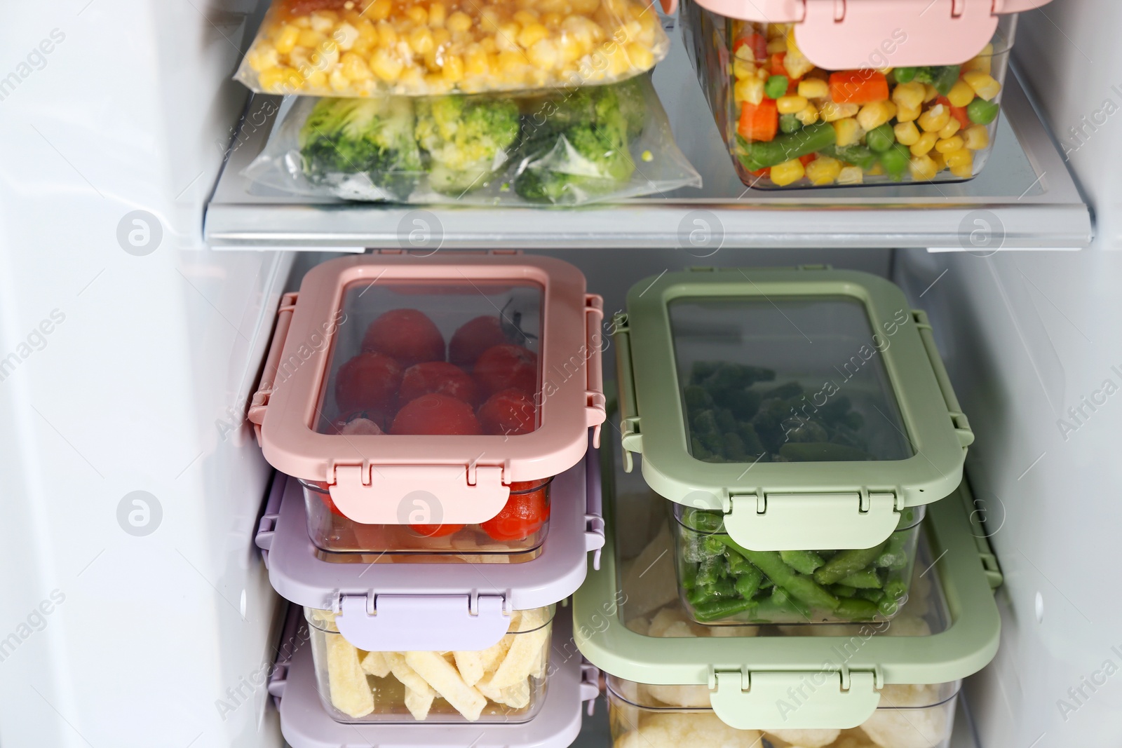 Photo of Plastic bags and containers with different frozen vegetables in refrigerator