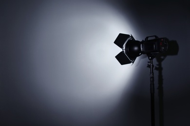 Photo of Professional photo studio lighting equipment on dark background. Space for text