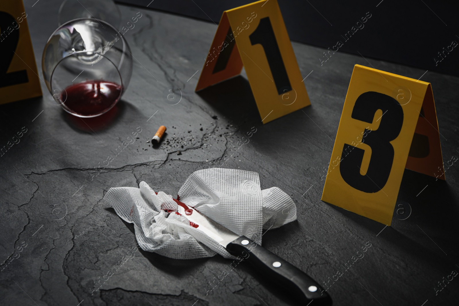 Photo of Crime scene markers and evidences on black background, closeup