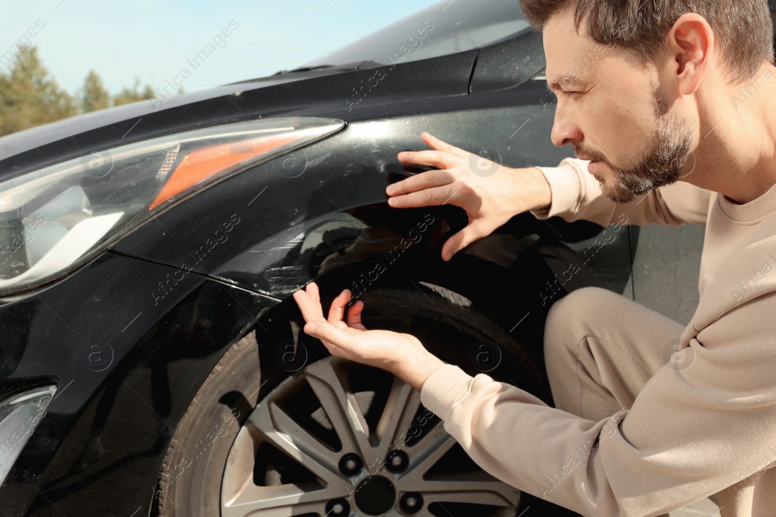 Photo of Stressed man near car with scratch outdoors