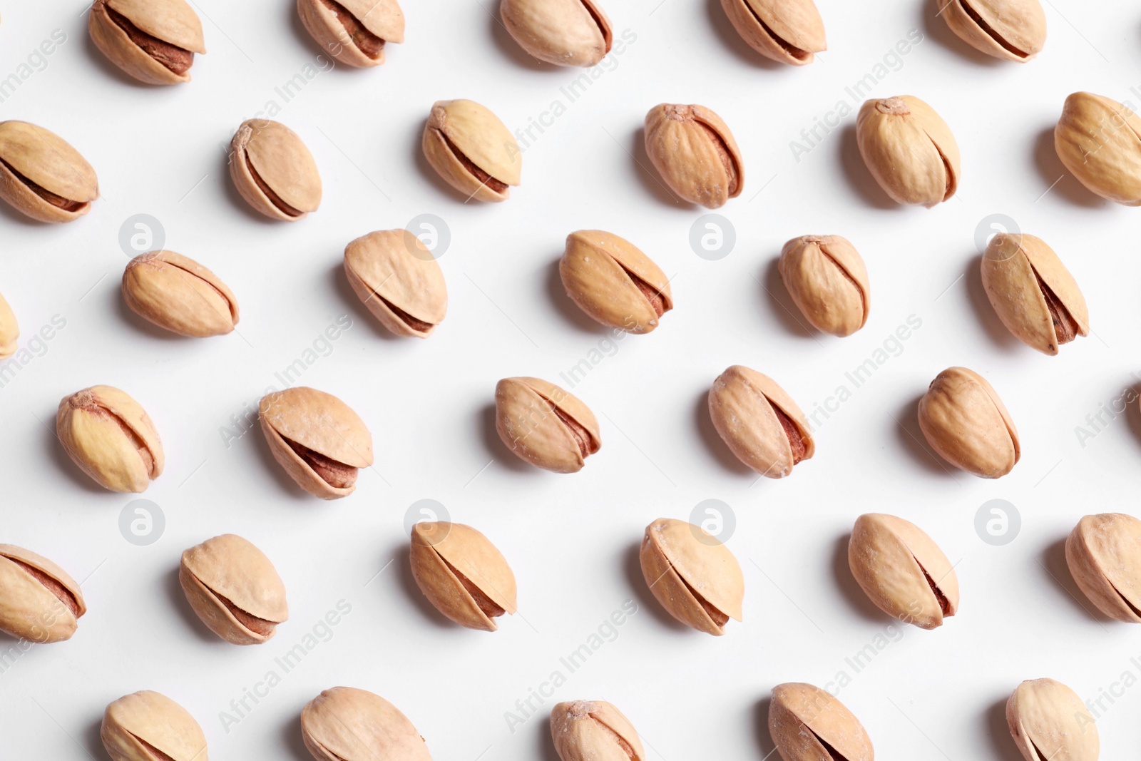 Photo of Organic pistachio nuts on white background, flat lay