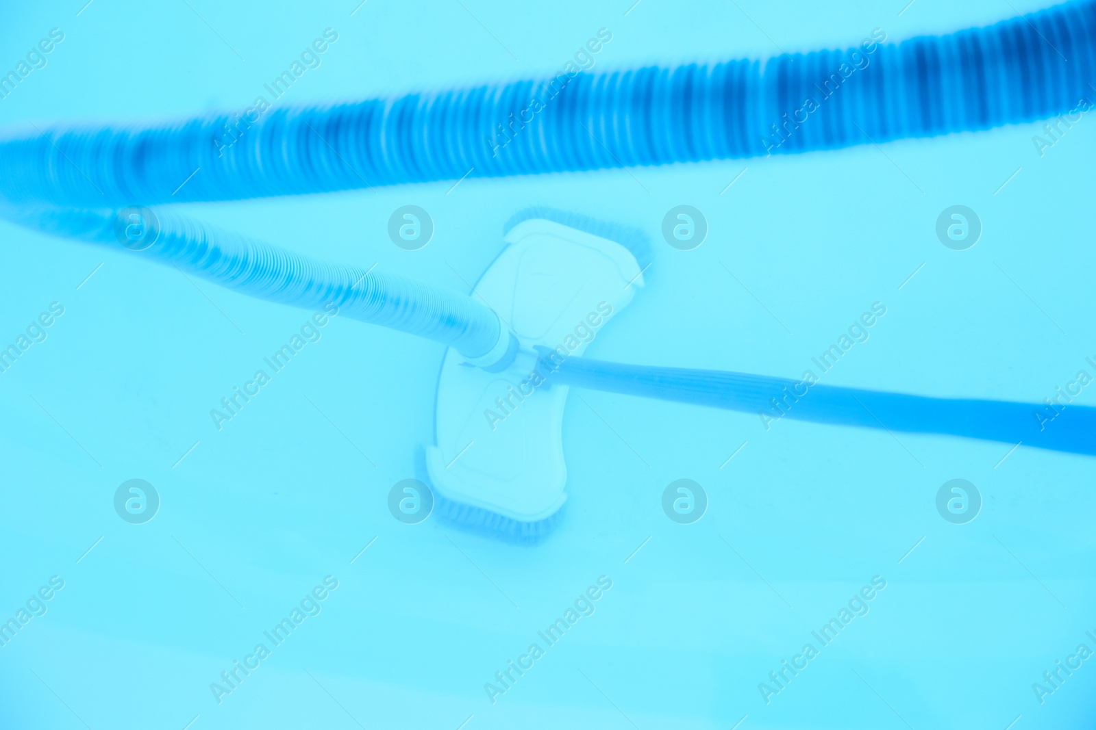 Photo of Cleaning outdoor swimming pool with underwater vacuum