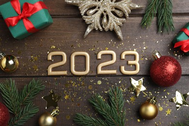 Photo of Flat lay composition with number 2023 and festive decor on wooden background. Happy New Year