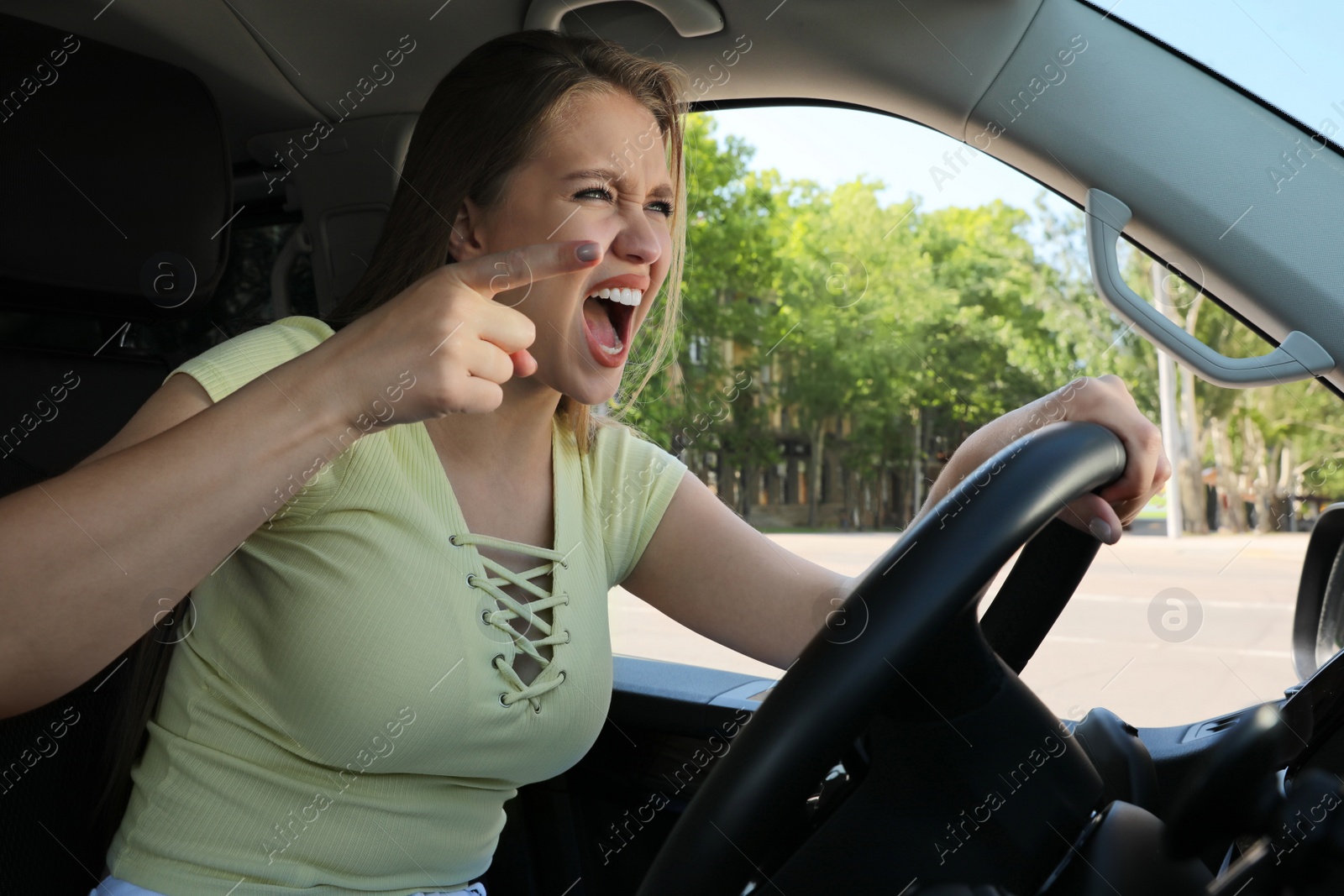 Photo of Emotional woman in car. Aggressive driving behavior