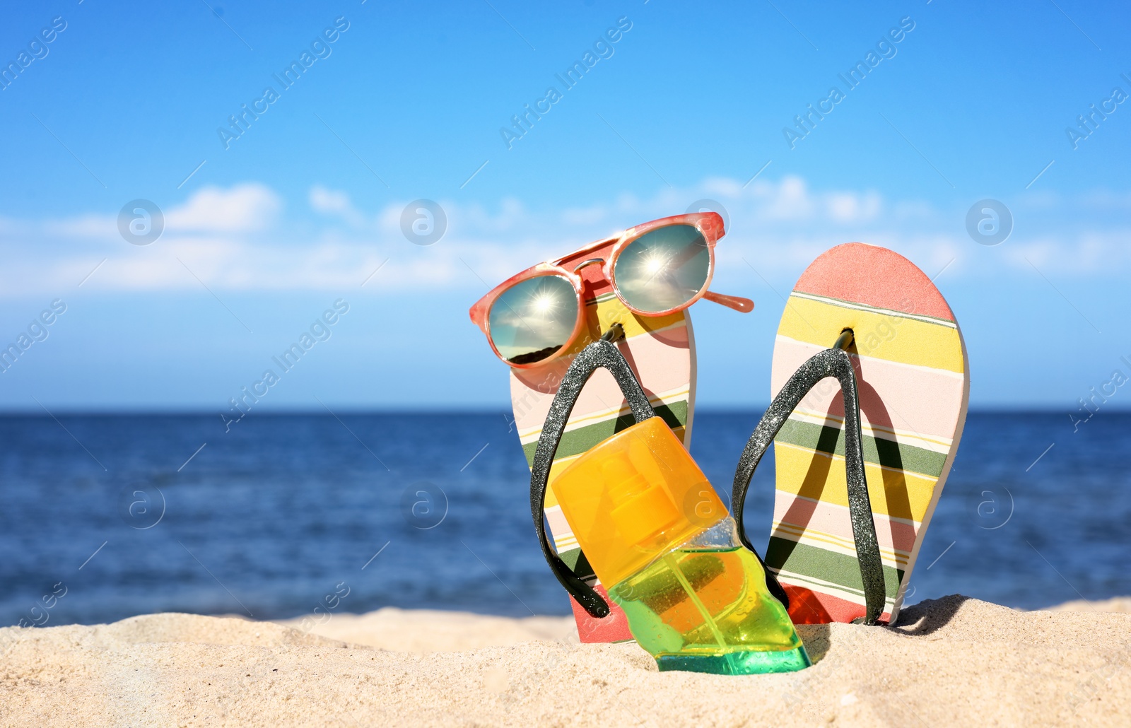 Photo of Composition with beach accessories on sand near sea in summer. Space for text