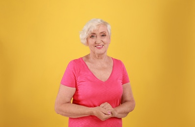 Senior woman in casual outfit on yellow background
