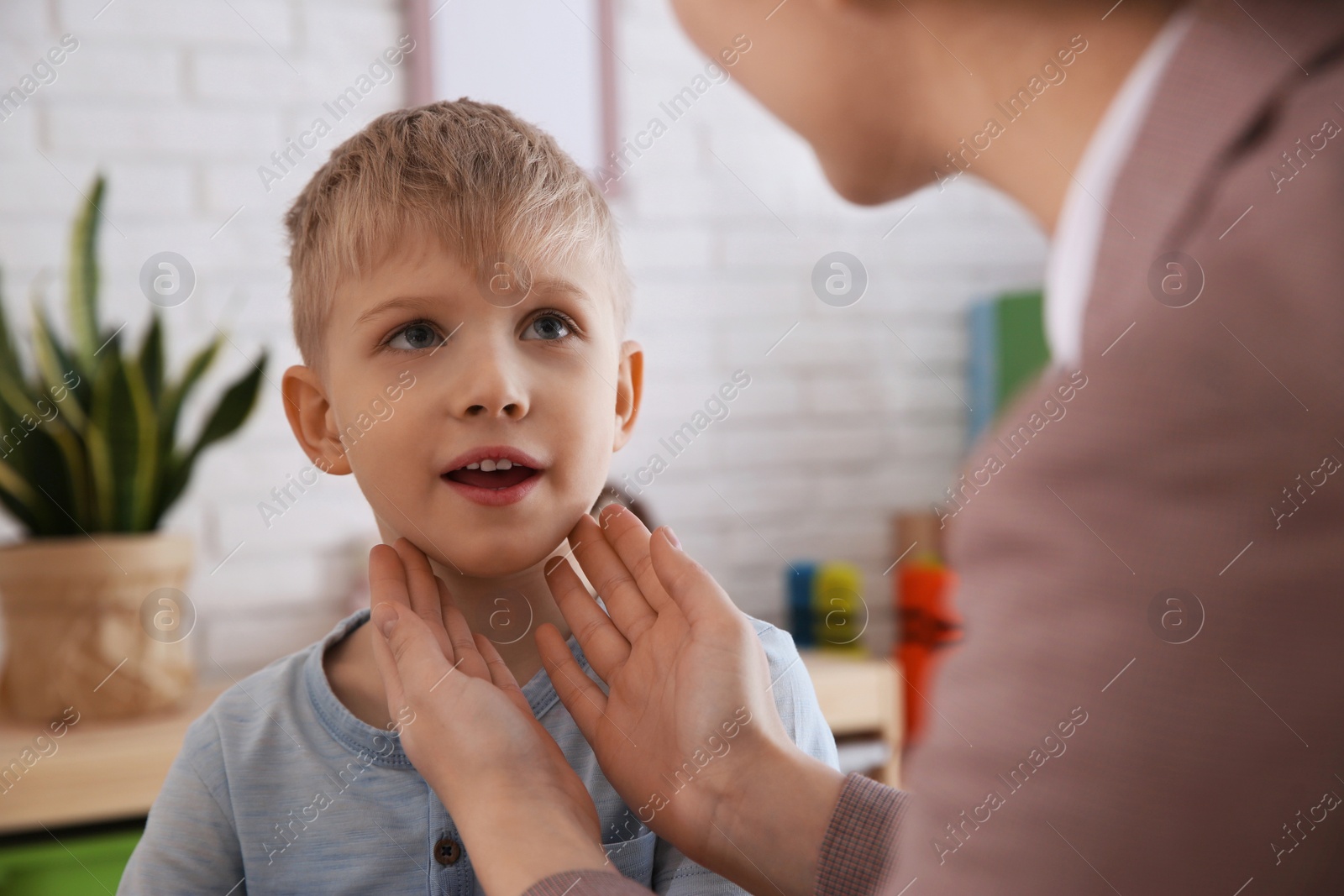 Photo of Speech therapist working with little boy in office