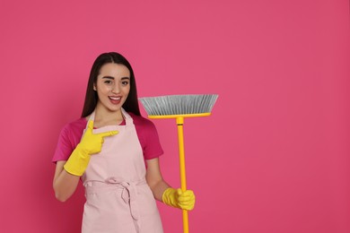 Beautiful young woman with broom on pink background. Space for text