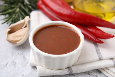 Photo of Fresh marinade and different ingredients on light grey textured table, closeup