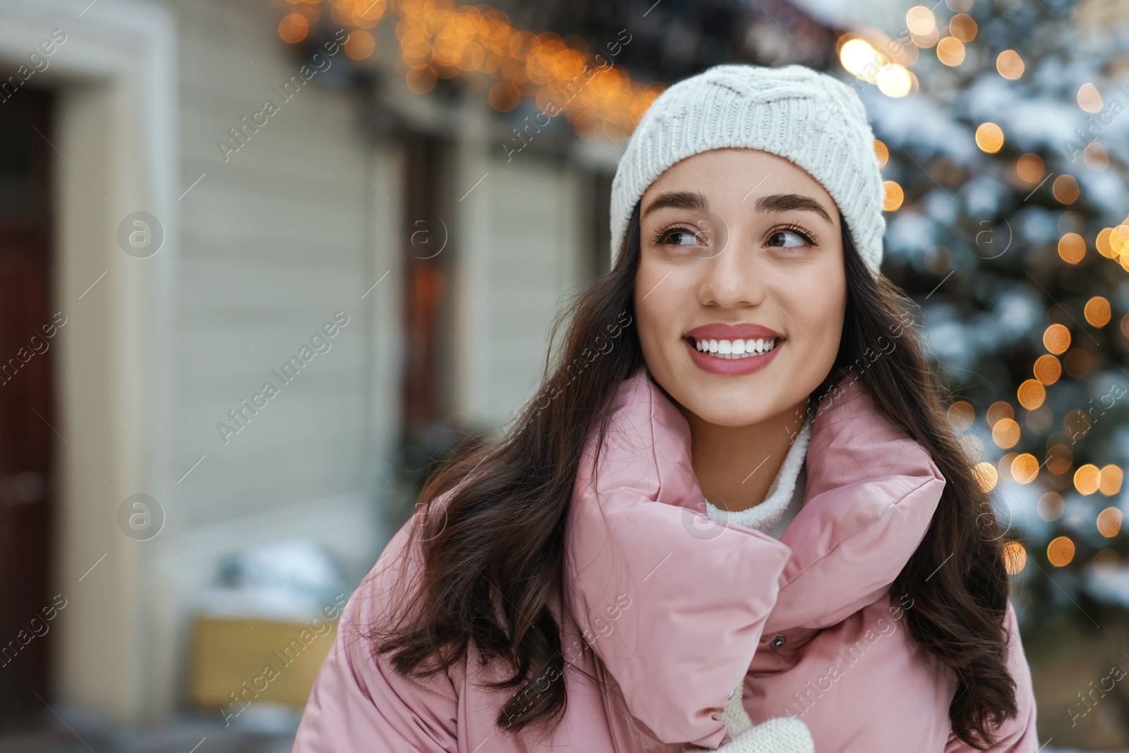 Photo of Portrait of smiling woman on city street in winter. Space for text