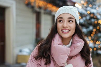 Portrait of smiling woman on city street in winter. Space for text