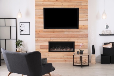 Photo of Living room interior with decorative fireplace in wooden wall