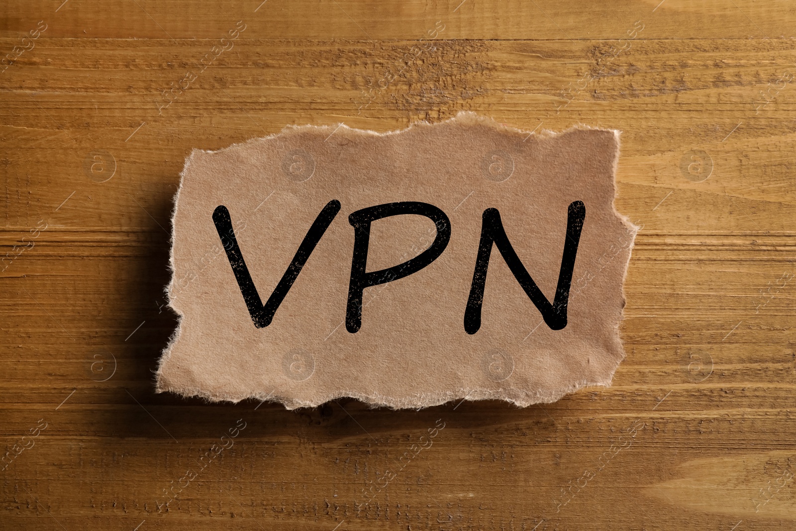 Photo of Paper note with acronym VPN on wooden table, top view