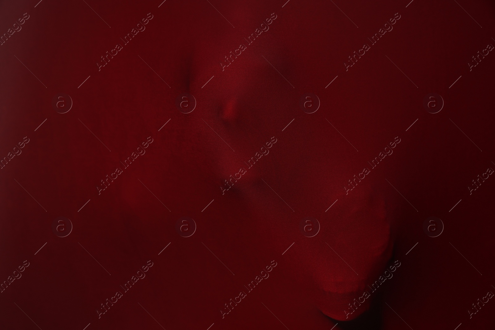 Photo of Silhouette of creepy ghost with skulls behind red cloth