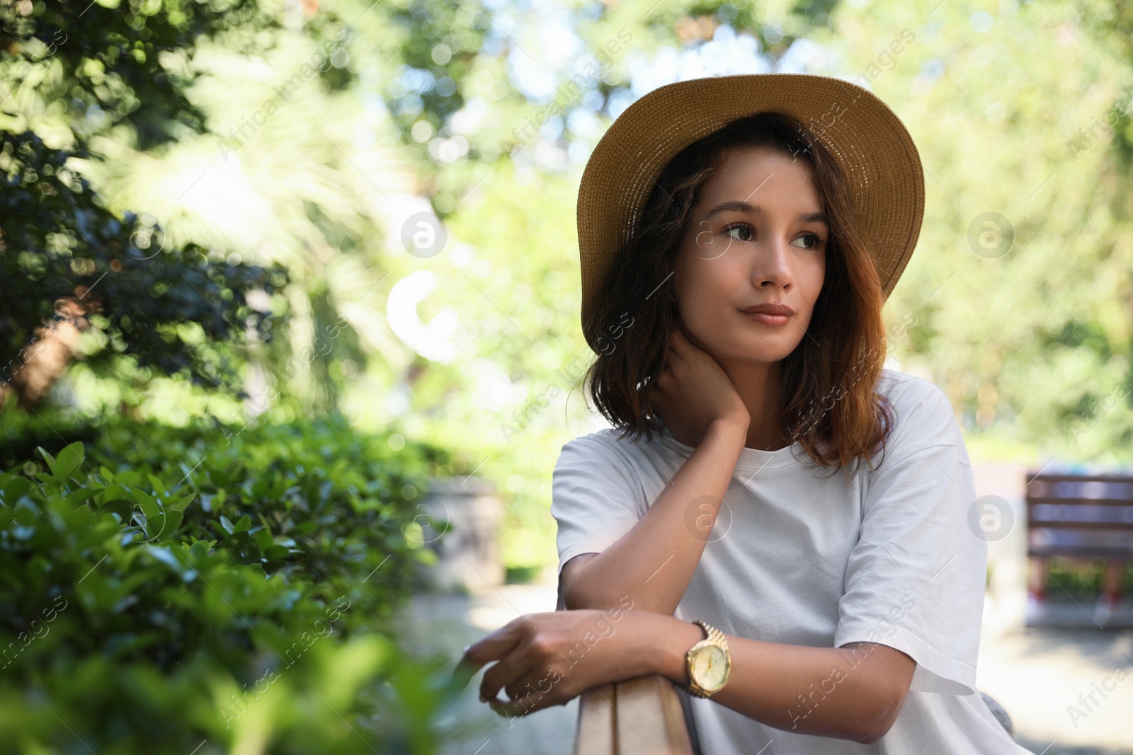 Photo of Portrait of beautiful young woman on bench in park. Space for text