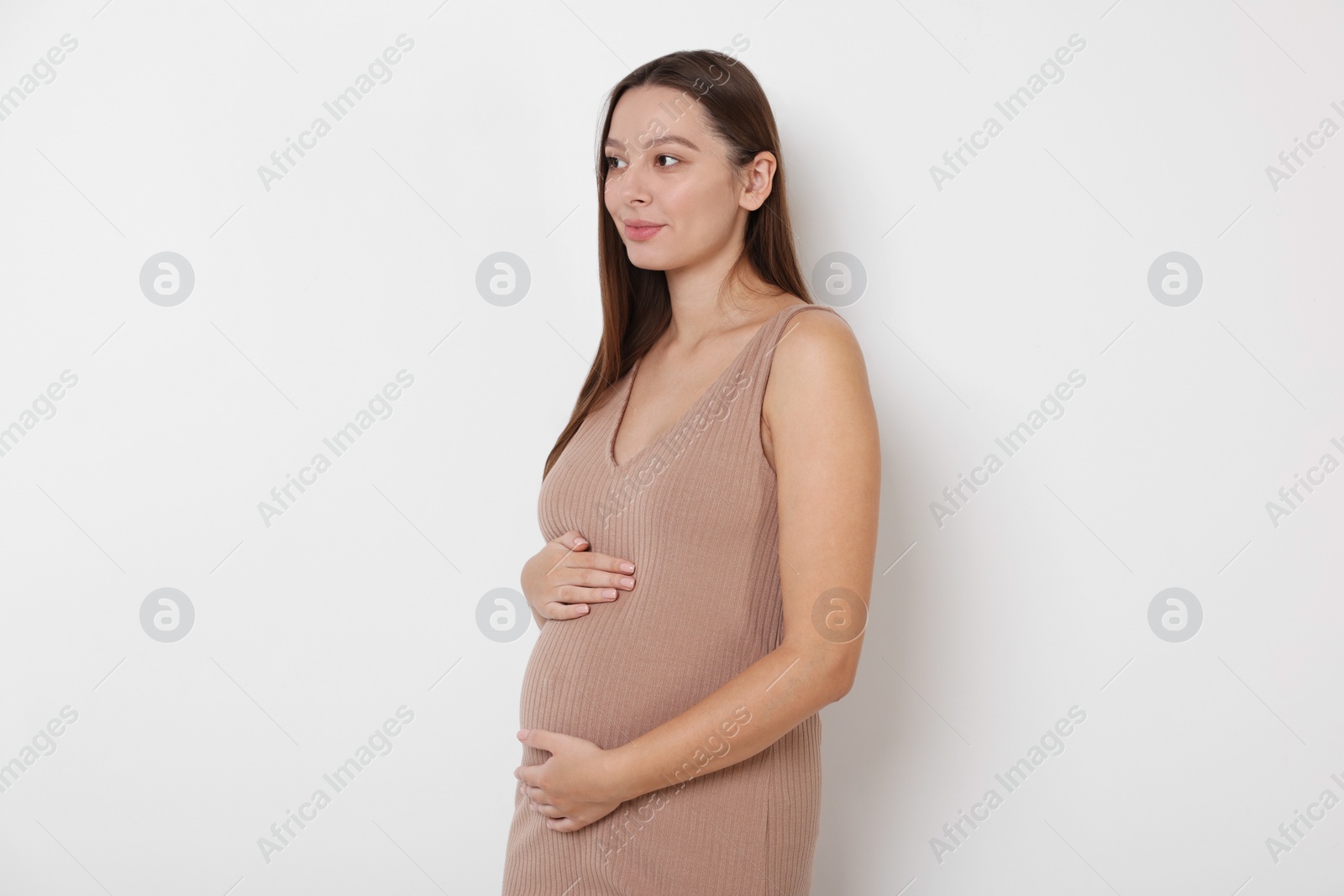 Photo of Beautiful pregnant woman in beige dress on white background