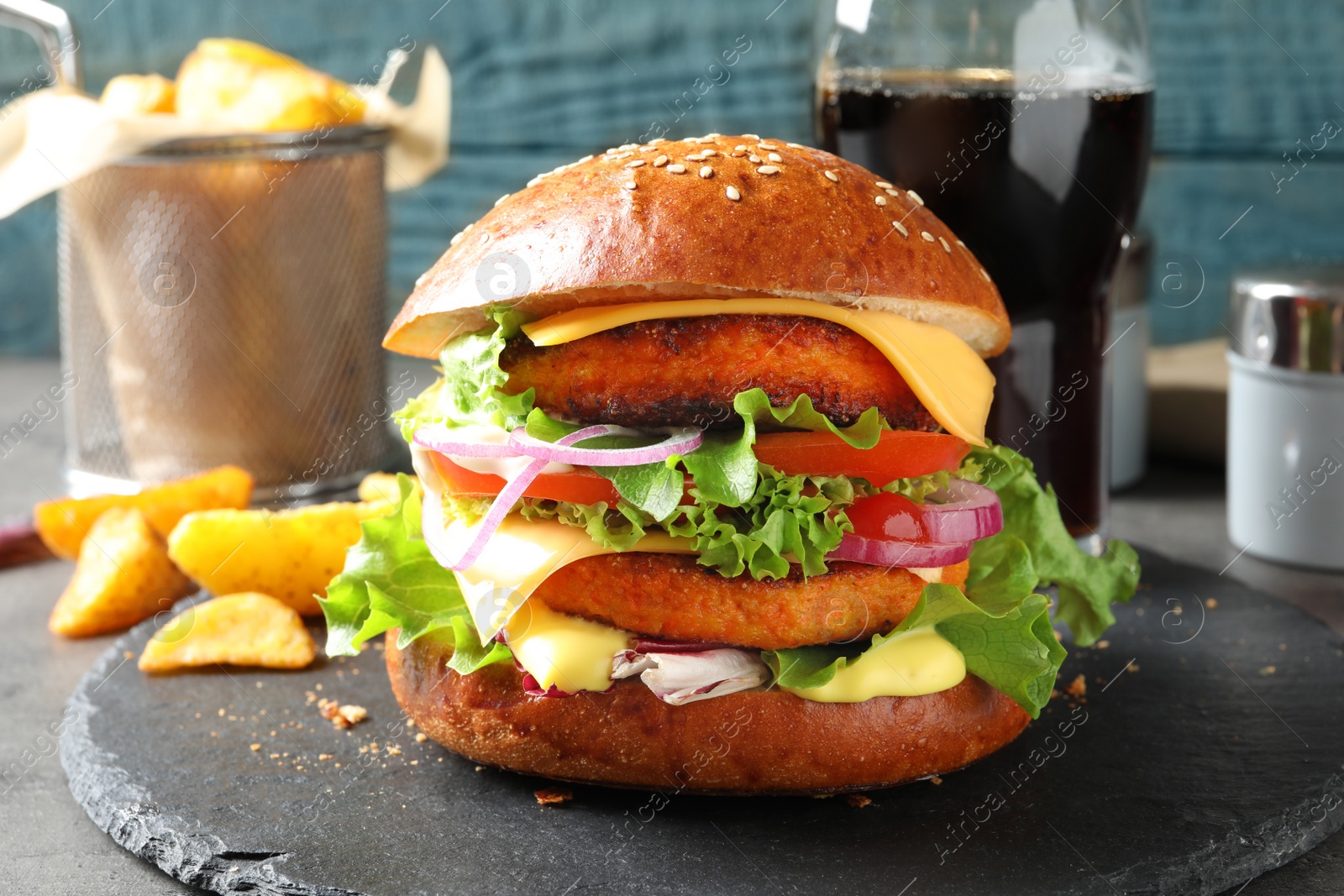 Photo of Slate plate with double vegetarian burger on table