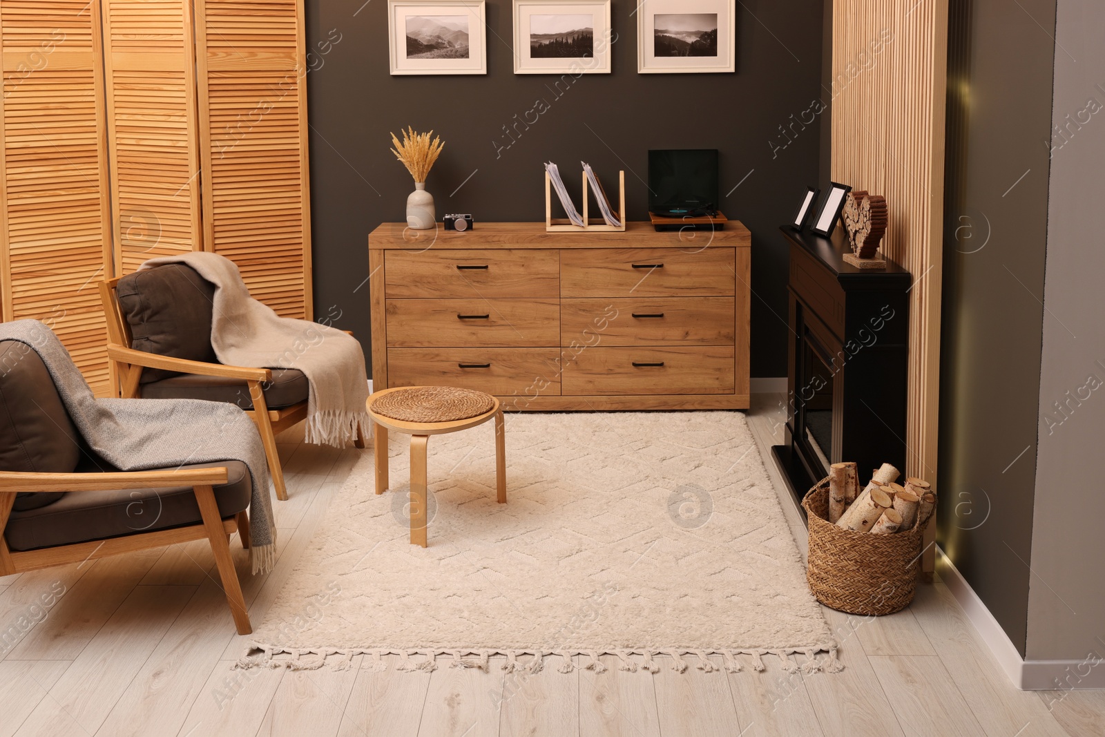 Photo of Stylish room with beautiful rug near fireplace. Interior design