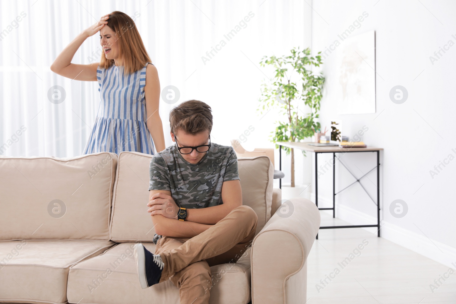 Photo of Mother scolding her teenager son at home