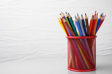 Many colorful pencils in holder on white background, space for text