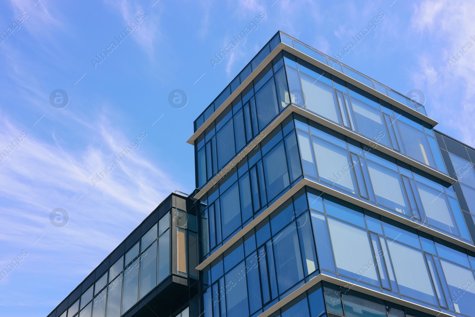 Photo of Low angle view of modern buildings against blue sky