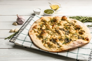 Photo of Traditional Italian focaccia bread with guacamole and rosemary on white wooden table