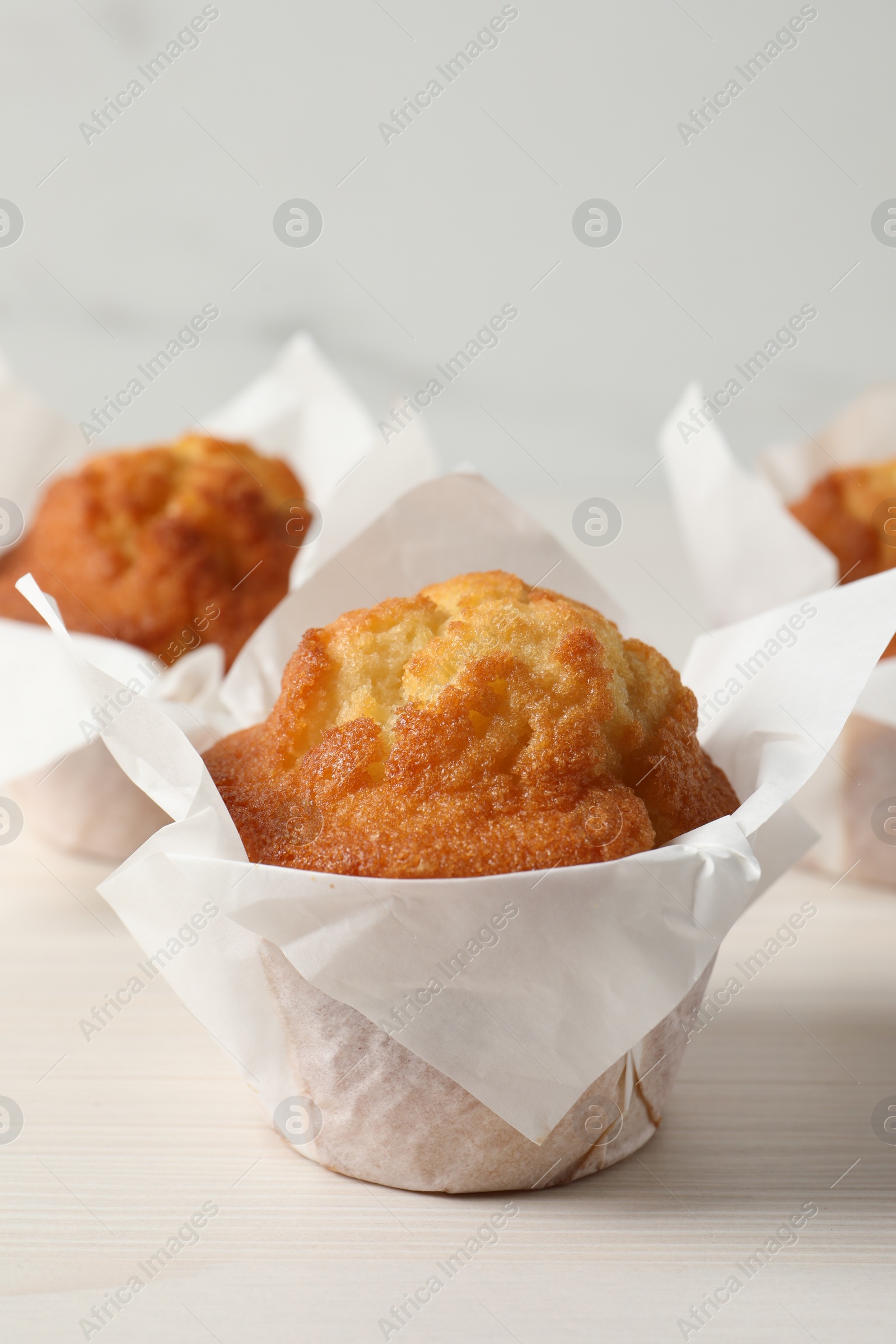 Photo of Tasty muffins on white wooden table, closeup. Fresh pastry