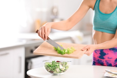 Photo of Young woman in fitness clothes preparing healthy breakfast at home, closeup