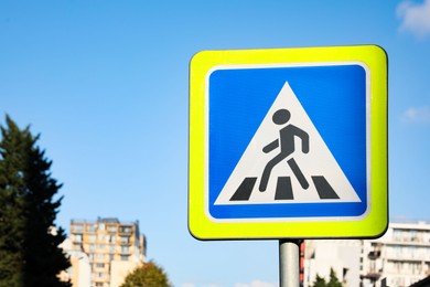 Photo of Road sign Pedestrian Crossing against blue sky on city street