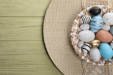 Photo of Many beautifully decorated Easter eggs on yellow wooden table, top view. Space for text