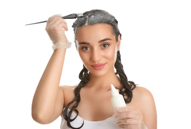 Photo of Young woman dyeing her hair against white background