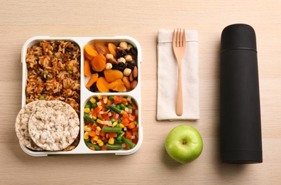 Flat lay composition with thermos and lunch box on wooden background