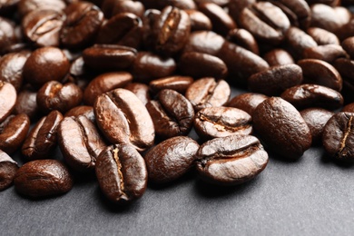 Roasted coffee beans on grey background, closeup