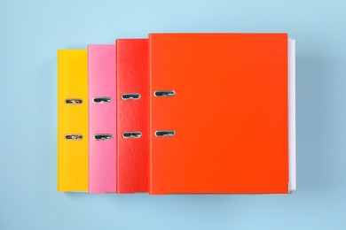 Many office folders on light blue background, flat lay