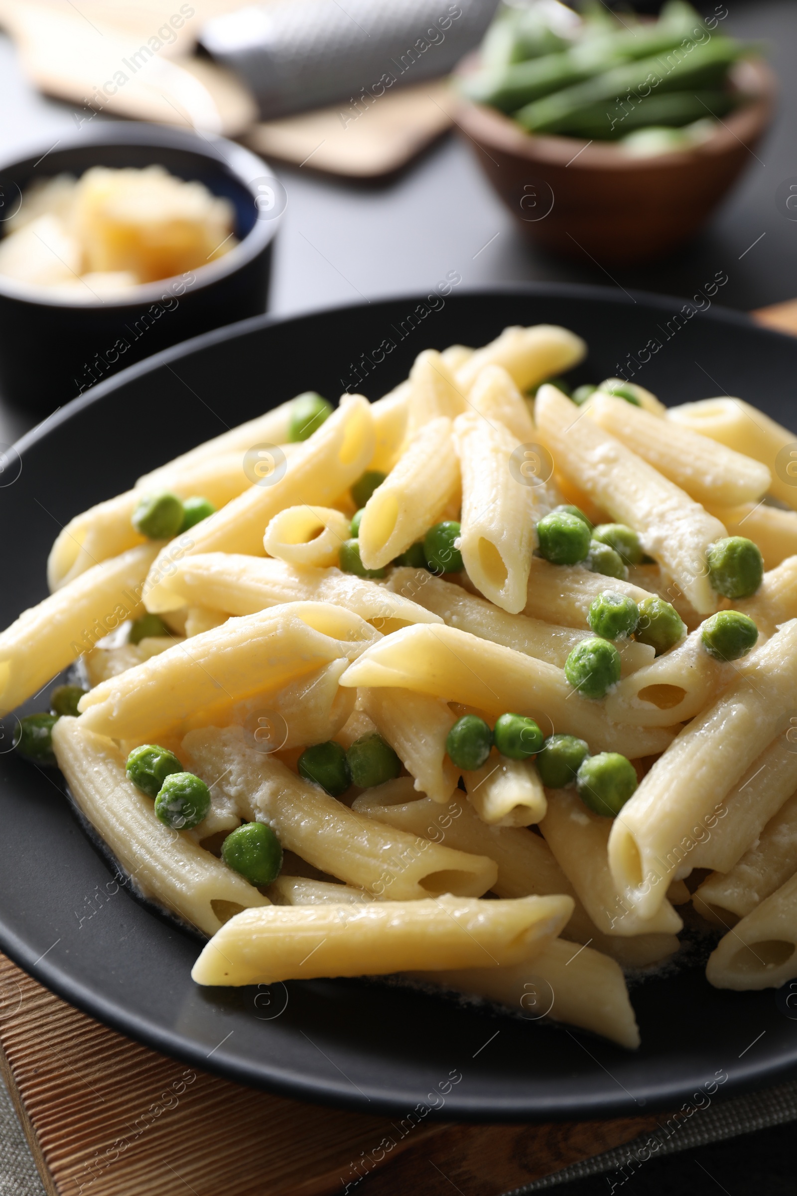 Photo of Delicious pasta with green peas and cheese on table, closeup