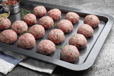 Photo of Many fresh raw meatballs on grey table
