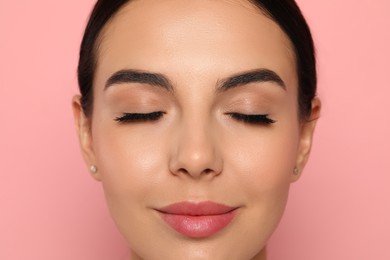 Photo of Beautiful young woman with long eyelashes on pink background, closeup