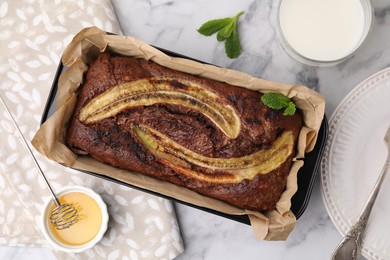 Delicious banana bread served on white marble table, flat lay