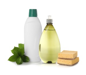 Photo of Bottles of cleaning product, sponges and green leaves isolated on white