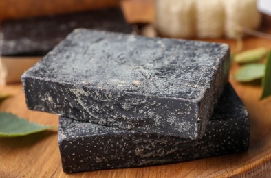 Photo of Tar soap on wooden table, closeup. Natural product