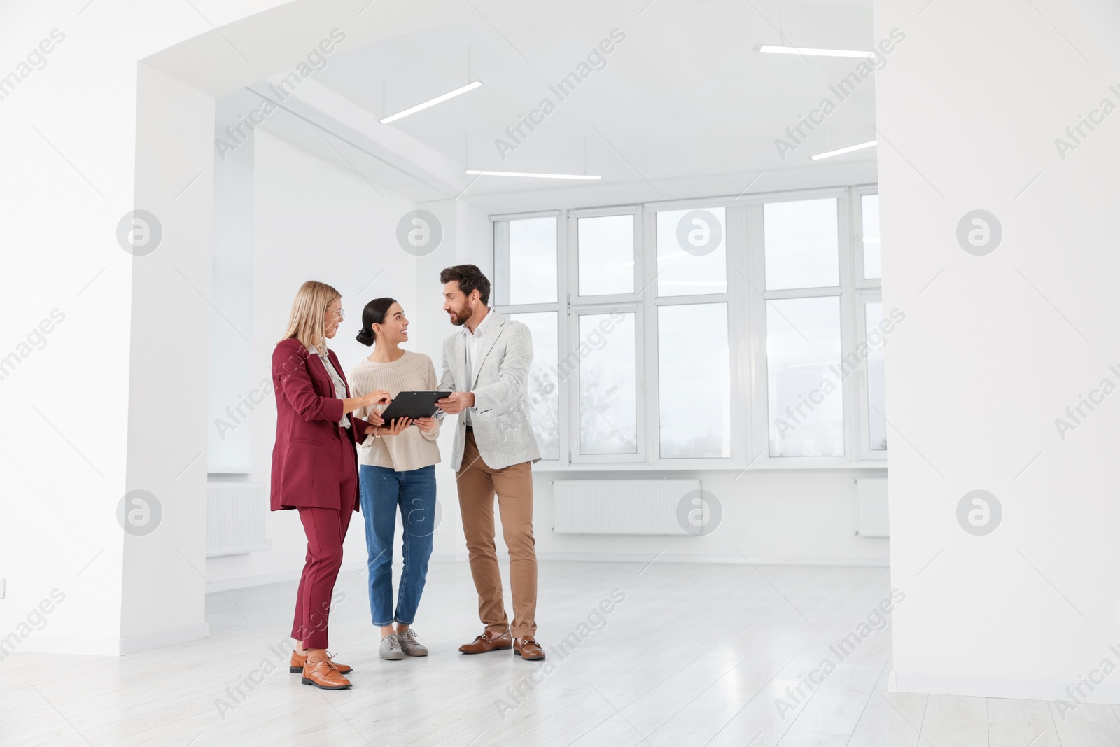 Photo of Real estate agent showing new apartment to couple