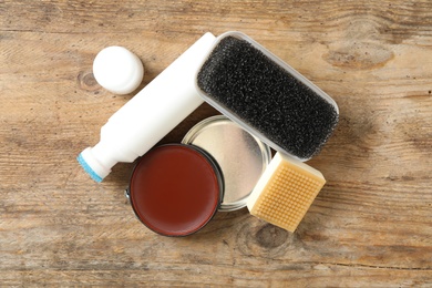 Photo of Flat lay composition with shoe care accessories on wooden background