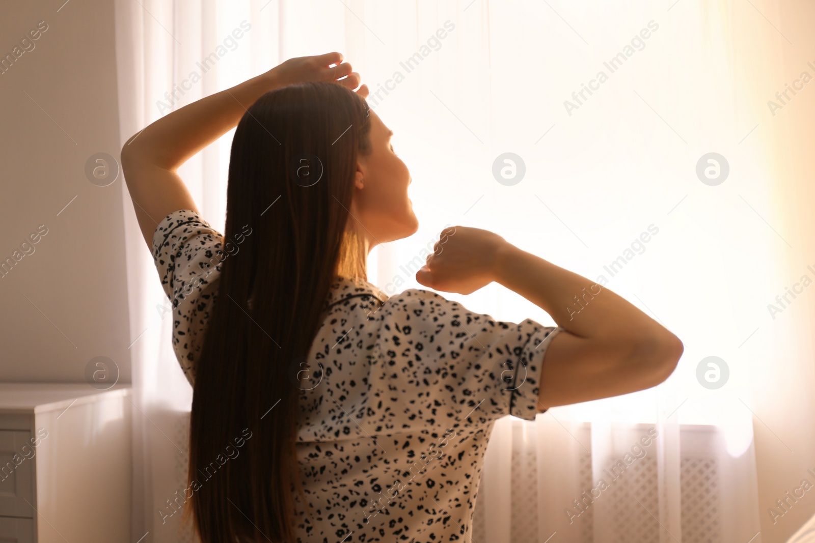 Photo of Young woman stretching at home. Lazy morning