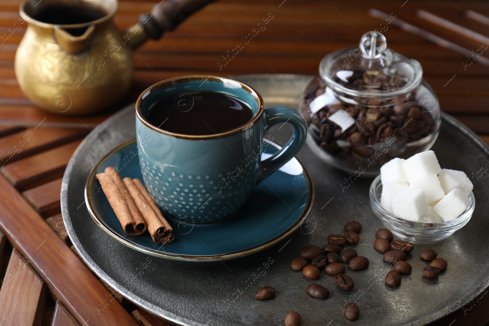 Photo of Turkish coffee. Freshly brewed beverage served on wooden table, closeup