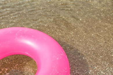 Photo of Bright inflatable ring floating on sea water. Space for text